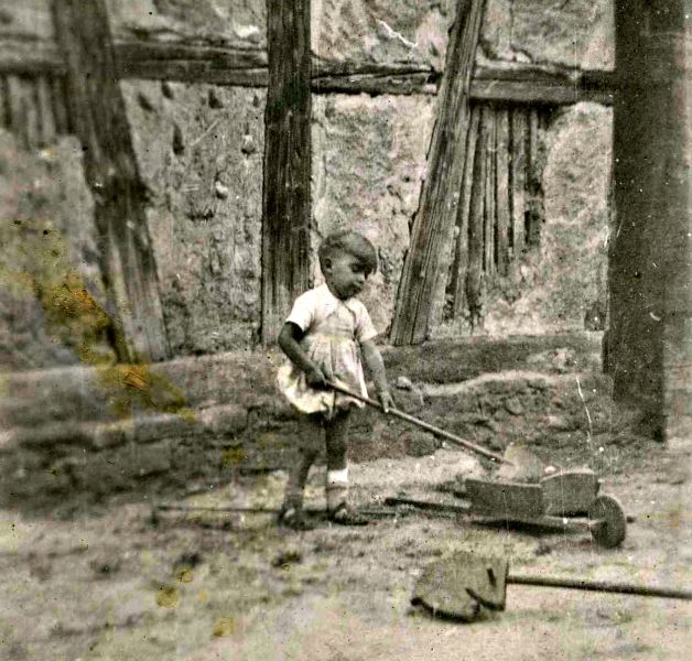 L’enfant invente tant de jeux devant son petit tas de sable.